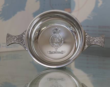A silver quaich with Britannia's crest in the center. 