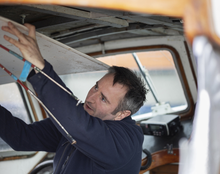 A roof panel being removed by a Maintenance team member in the Fast Motor Launch boat.
