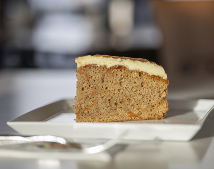A slice of carrot cake on a white plate. 