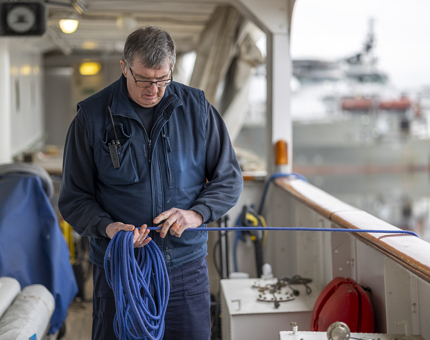 A Maintenance team member prepping ropes to move the Berthing Cat.