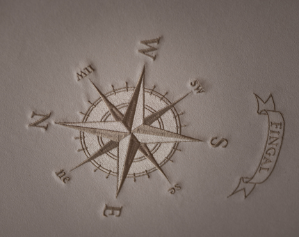 A detailed look at a stitched compass in one of Fingal Hotel's bedrooms.