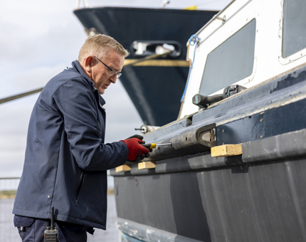 A Maintenance man working on the Fast Motor Launch boat.