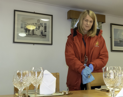A Housekeeper polishing cutlery. 