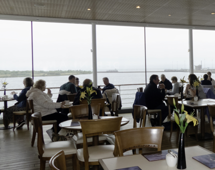 Visitors sitting at tables in the Royal Deck Tea Room. 