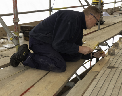 A member of the Maintenance team attending to woodwork. 