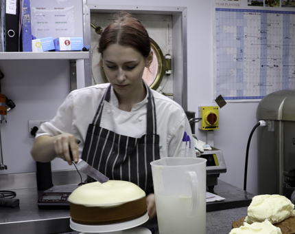 Amelia, Demi-Chef de Partie, applies the frosting to each of the cakes..jpg