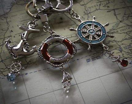 Nautical-style keyrings of an anchor, lifebelt which reads 'Welcome Aboard' and a ship's steering wheel. 