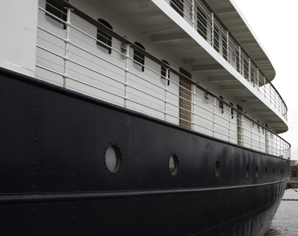 Exterior of Fingal from a low viewpoint shows the outside doors of cabins and portholes. 