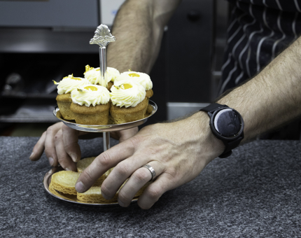 A cake stand containing miniature cupcakes and rounds of shortbread. 