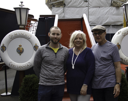 Family group of two men and one woman pose standing next to Britannia's Royal Brow. 