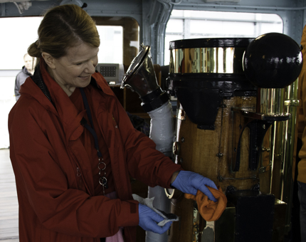Housekeeper polishes brass within Britannia's Bridge.