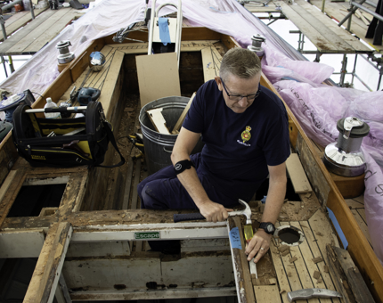 Maintenance member of team holds hammer to remove decking. 