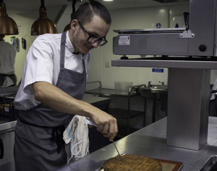 Chef checks a butter cake in the Galley. 