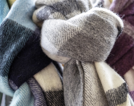 Three lambswool checked scarves in green, grey and pink.