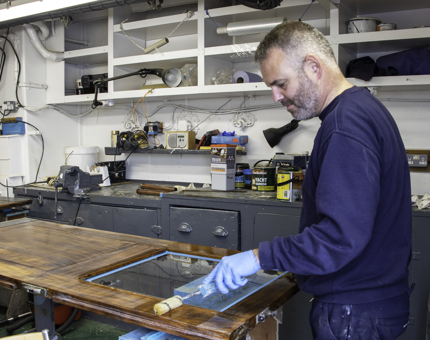 A member of the Maintenance team varnishes one of the Bridge doors. 