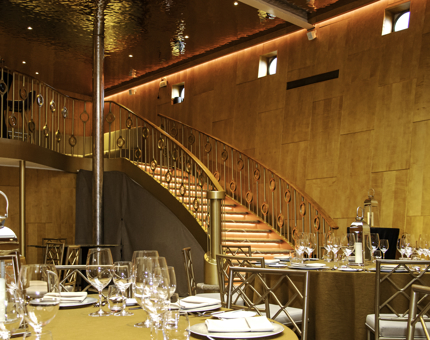 The Ballroom at Fingal. Tables are set for dinner and a sweeping staircase leads upstairs to a bar.