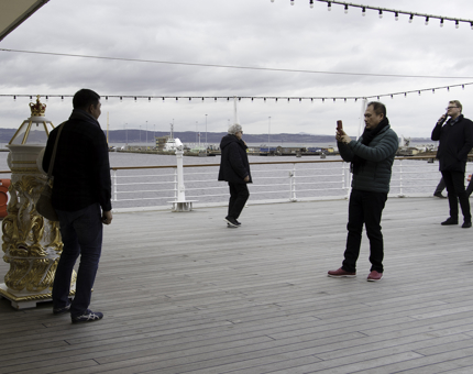 Visitors take photographs of each other on the Verandah Deck.