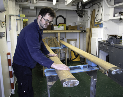 Maintenance team member prepares handrails within Britannia's workshop.