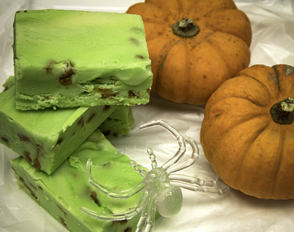 Tablets of green-coloured fudge and ornamental miniature pumpkins. 