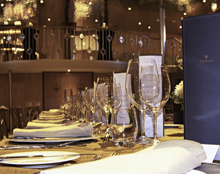 A table set for an exclusive event in Fingal's Ballroom. There are plates, cutlery, napkins and glasses on the table. 