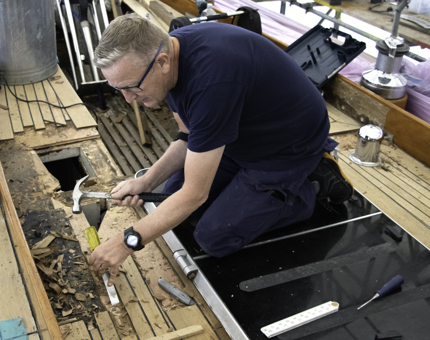 A member of Maintenance is removing sections of decking on Bloodhound. 