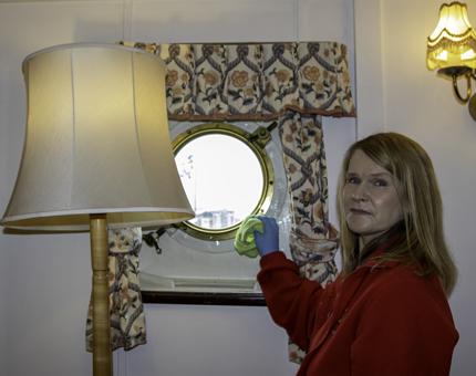 A Housekeeper working in the Admiral's Cabin. 