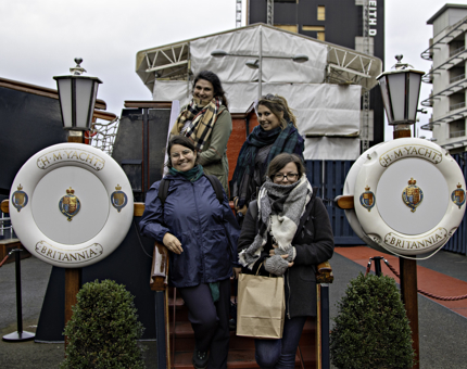 A group of visitors stand on the stairs of the Royal Brow posing for a photo. 