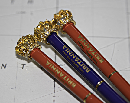 Two red and one blue Britannia pencils with gold crown toppers. 