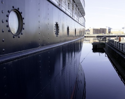 Side exterior view of Fingal in the water with late afternoon winter sunshine.