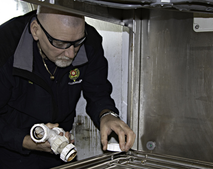 A man plumbing in a dishwasher. 