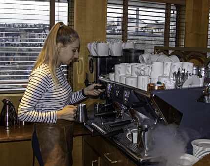 Waiter heats milk at the coffee machine in Fingal's Lighthouse Restaurant & Bar.