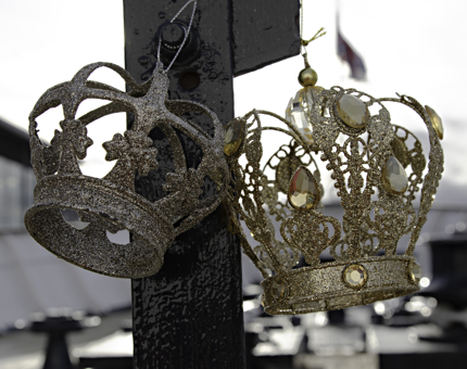 Two gold glittery crown-shaped hanging decorations. 