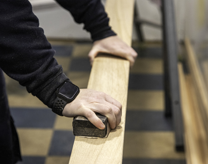 A closer look at the sanding of the wooden plank.