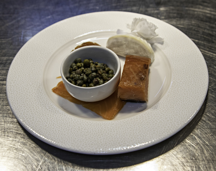 A plate containing a platter of fish for breakfast. 