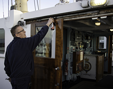 Maintenance team member checks the door runners on the Bridge. 