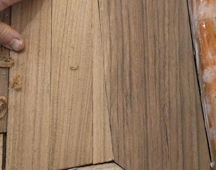 Close-up view of length of wood being fitted into place. 