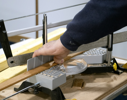 Member of the Maintenance Team cutting a length of beading.