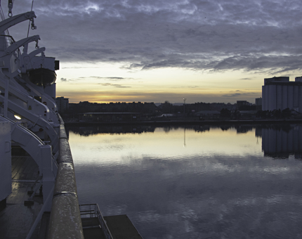 The sun sets along Leith with the side of Britannia on the left. 