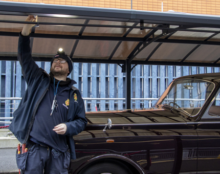 Maintenance man replacing a light bulb within the canopy covering the Rolls Royce. 