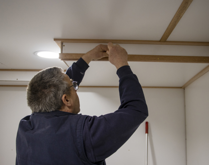 Maintenance team member affixing the beading in Britannia's Training Room. 