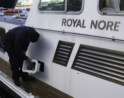 A man holding a white compartment box next to vessel Royal Nore. 