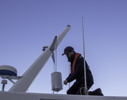 Maintenance team member installing a radar reflector on Royal Nore. 