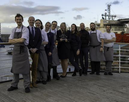 A group of crew members from Fingal pose on deck with the Pride of Britain award for Hotel of the Year.