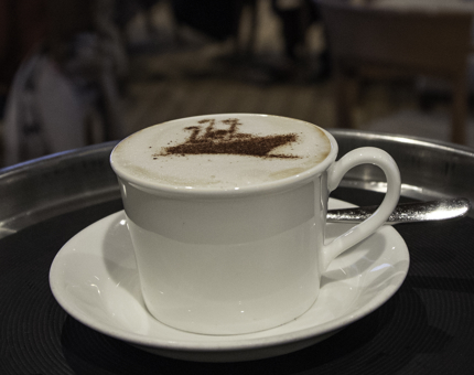 A close-up of a cappuccino with a stencil of Britannia's outline in chocolate on top.