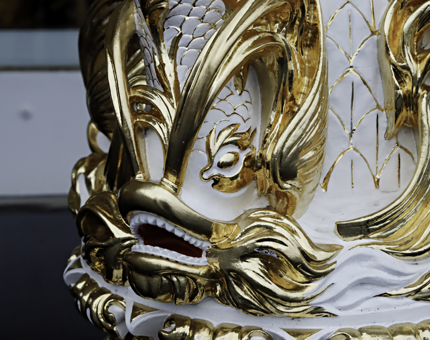 A close-up detail of the ornate gold decorated binnacle compass. 