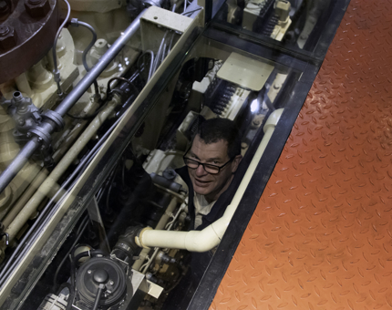 The Director of Maintenance looks up through the floor in the Engine Room at Fingal.