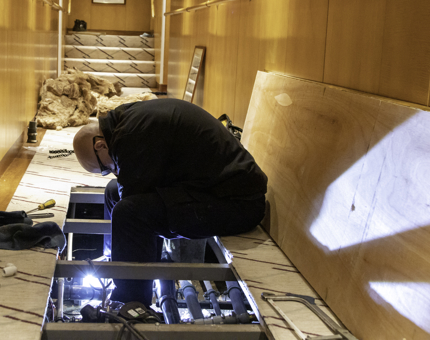 A man sits removing the Vacuum Interface Boxes from the void.