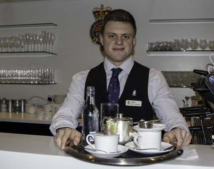 A Waiter in the Tea Room holding a tray of hot drinks.