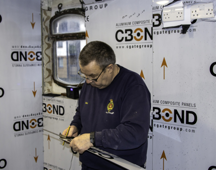 A man fitting wipeable panels into the Fingal Galley.