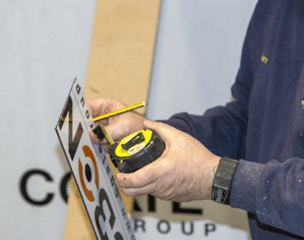 A close-up of a man measuring up for wipeable panels.